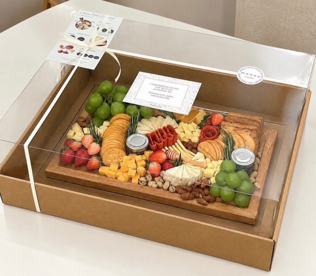 Cheese and fruit platter with crackers and nuts in a gift box.