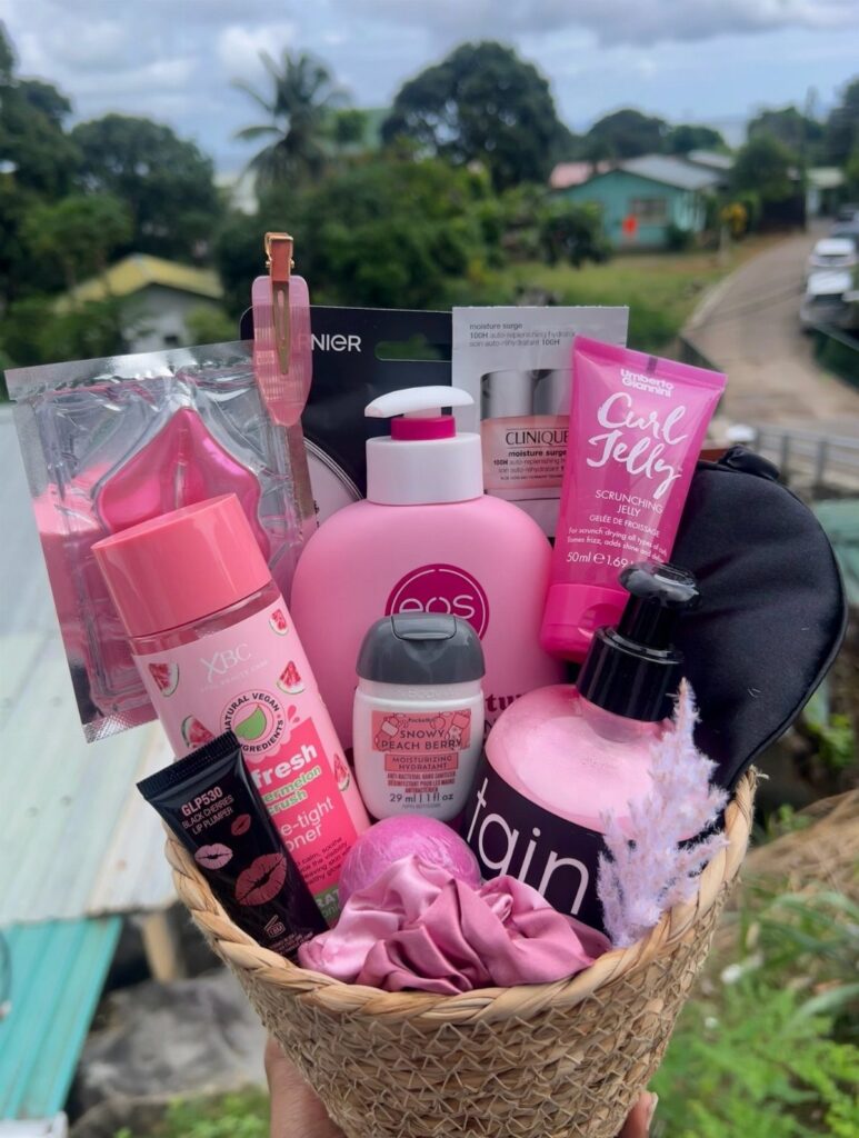 Woven basket filled with pink skincare products, beauty tools, and a silk scrunchie.