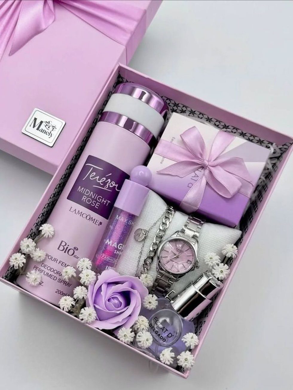Pink gift hamper for women with perfume, watch, jewelry, and purple roses.