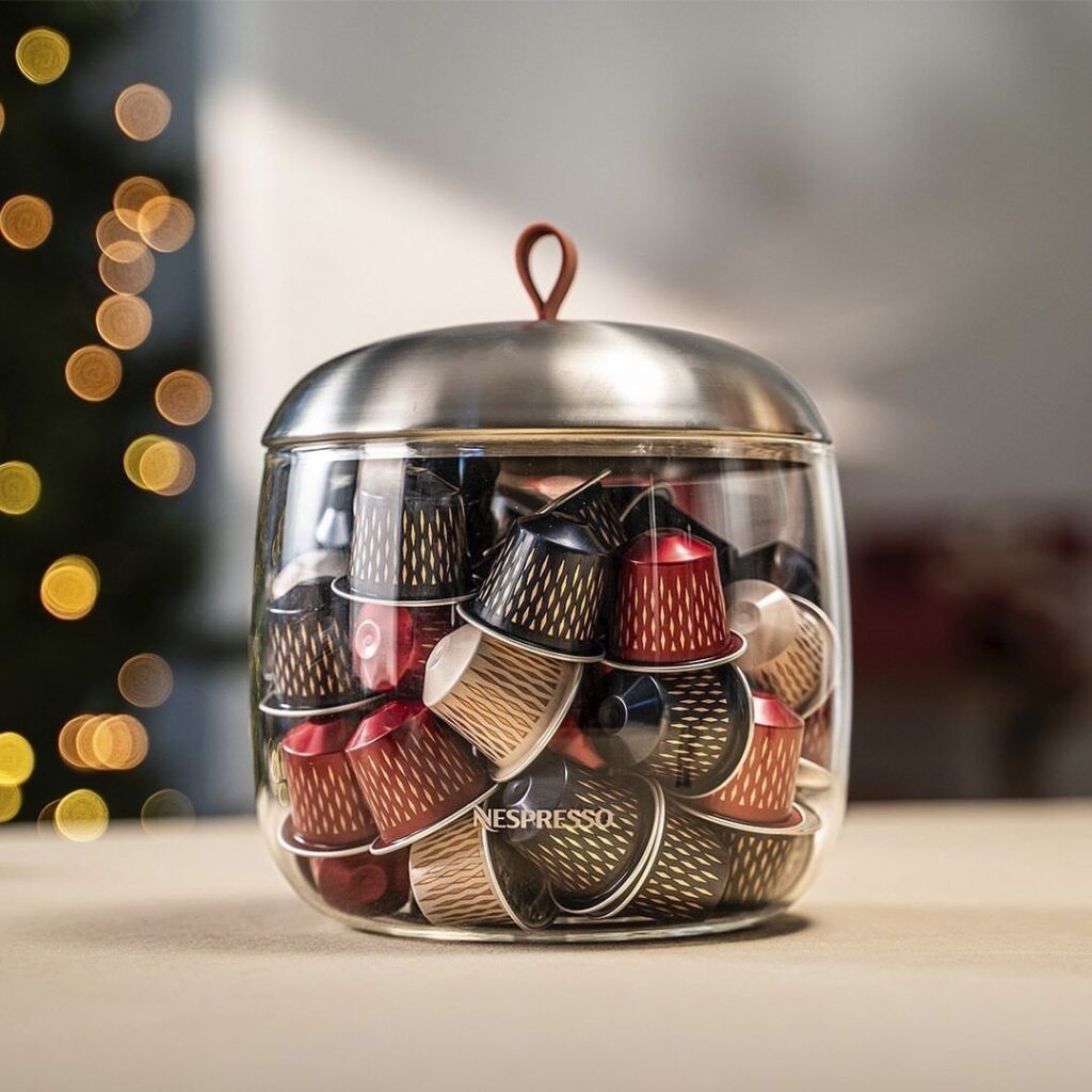 Glass jar with silver lid filled with colorful Nespresso coffee pods