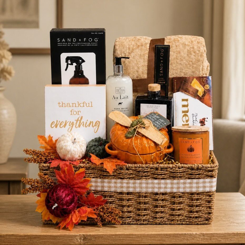 Woven gift basket filled with autumn skincare products, a candle, and fall decorations.