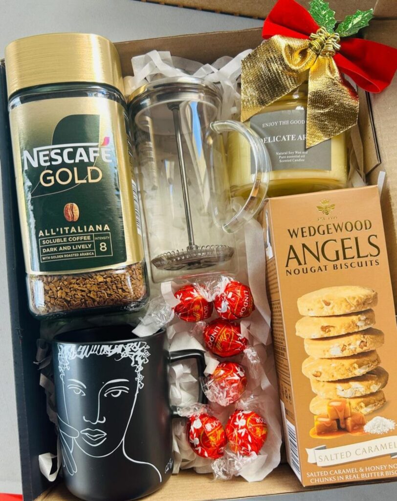 Coffee gift basket with Nescafe Gold, French press, black mug, and salted caramel biscuits.
